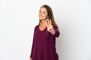 Beyaz arka planda izole edilmiş orta yaşlı Brezilyalı kadın mutlu ve parmaklarıyla üçe kadar sayıyor.