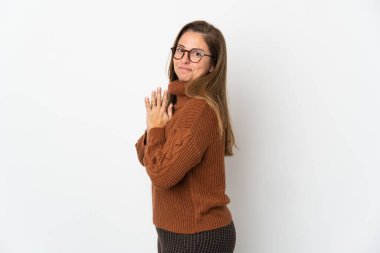 Orta yaşlı Brezilyalı bir kadın beyaz arka planda bir şeyler çeviriyor.