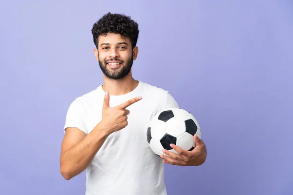 Young Moroccan Man Isolated Purple Background Soccer Ball Pointing Lateral — Stock Photo, Image