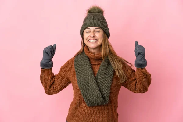 Medelålders Kvinna Med Vinter Hatt Isolerad Rosa Bakgrund Gör Stark — Stockfoto