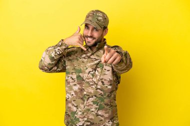 Askerler sarı arka planda izole edilmiş telefon hareketleri yapıyor ve ön tarafı işaret ediyorlar.