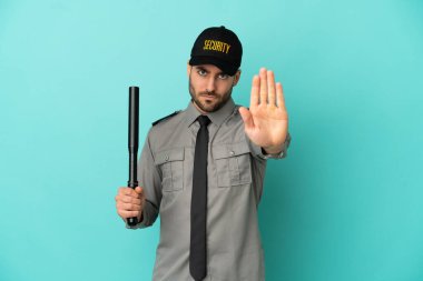 Genç güvenlik görevlisi mavi arka planda izole edildi.