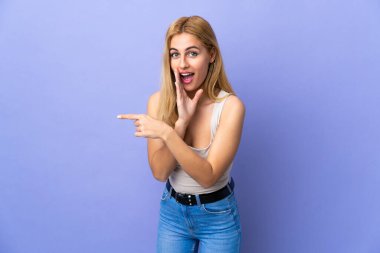 Genç Uruguaylı sarışın kadın bir ürünü sunmak ve bir şeyler fısıldamak için kenarı işaret ediyor.