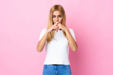 Genç Uruguaylı sarışın kadın izole pembe arka planda sessizlik işareti gösteriyor.