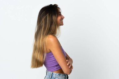 Beyaz arka planda yalıtılmış beyaz tenli genç bir kadın var.