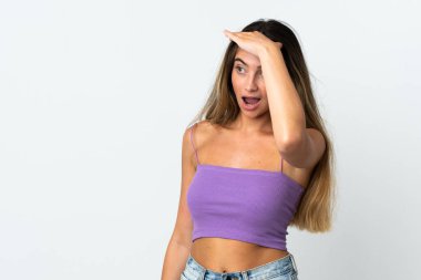 Beyaz arka planda beyaz tenli genç bir kadın. Sürpriz bir ifadeyle yan tarafa bakıyor.