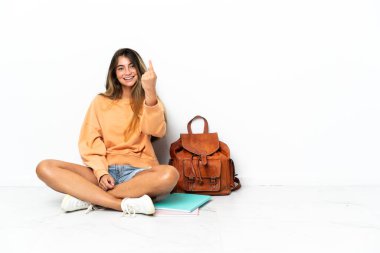 Yerde dizüstü bilgisayarlı genç bir bayan oturuyor beyaz arka planda izole edilmiş bir şekilde.