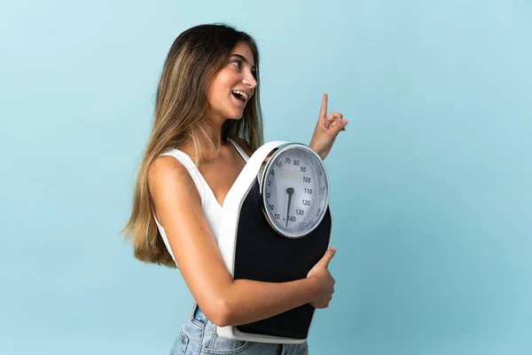 Mujer Joven Caucásica Aislada Sobre Fondo Azul Con Máquina Pesaje — Foto de Stock