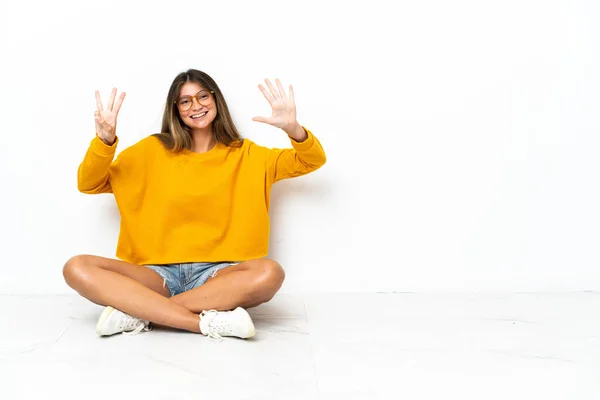 Mladá Žena Sedí Podlaze Izolované Bílém Pozadí Počítání Osm Prsty — Stock fotografie