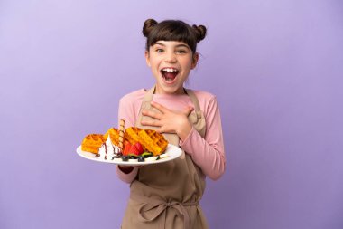 Mor arka planda gözleme tutan küçük beyaz kız sağa bakarken şaşırmış ve şok olmuştu.