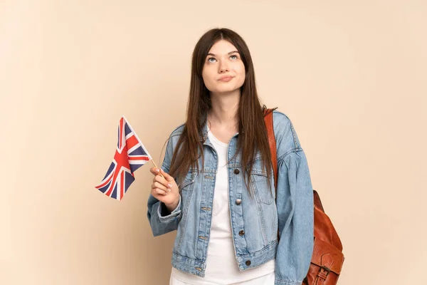 Młoda Ukraińska Dziewczyna Trzyma Flagę Wielkiej Brytanii Izolowane Beżowym Tle — Zdjęcie stockowe