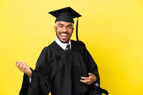 Junger Kolumbianischer Universitätsabsolvent Isoliert Auf Gelbem Hintergrund Mit Gitarrengeste — Stockfoto