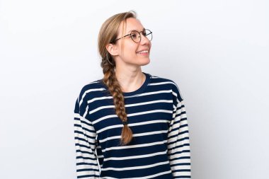 Beyaz arka planda izole edilmiş genç beyaz kadın yukarı bakarken bir fikir düşünüyor.