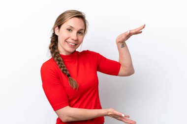 Beyaz arka planda izole edilmiş genç beyaz bir kadın ilan vermek için kopyalama alanı tutuyor.