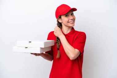 Pizza dağıtan kadın, iş üniformalı beyaz arka planda izole pizza kutuları alıyor ve zaferi kutluyor.
