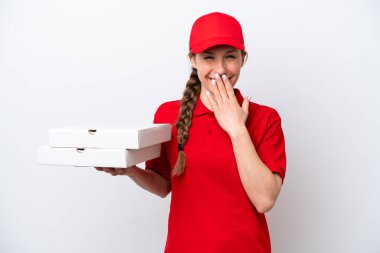 Pizza dağıtan kadın iş üniformalı beyaz arka planda izole edilmiş pizza kutuları alıyor mutlu ve ağzı kapalı gülümsüyor.