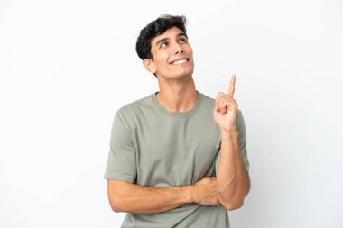 Beyaz arka planda izole edilmiş genç Arjantinli adam harika bir fikre işaret ediyor.