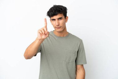 Beyaz arka planda izole edilmiş genç Arjantinli adam ciddi ifadeli birini sayıyor