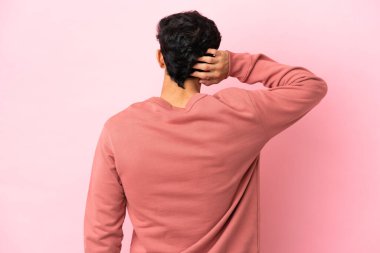 Arjantinli genç adam arka planda pembe arka planda izole edilmiş ve düşünüyor