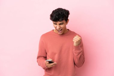 Pembe arka planda izole edilmiş genç Arjantinli adam şaşırdı ve bir mesaj gönderiyor.