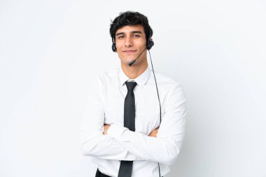 Tele pazarlamacı beyaz arka planda kolları bağlı ve ileriye bakan bir kulaklıkla çalışıyor.