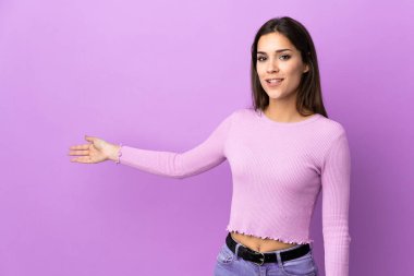 İzole edilmiş arka planda genç beyaz kadın, davet edilmek için ellerini yana uzatıyor.