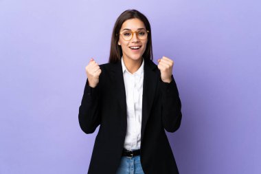 Mor arka planda izole edilmiş bir iş kadını zaferi kutluyor.