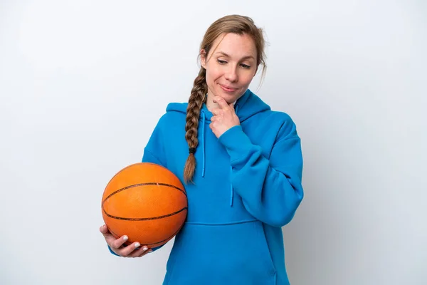 若いですCaucasian女性プレーバスケットボール孤立した上に白い背景を見ますザ 側と笑顔 — ストック写真