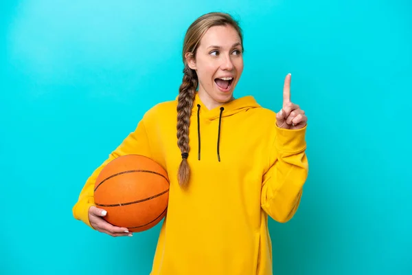 被蓝色背景隔离的年轻的高加索女人打篮球 并有一个想法 — 图库照片