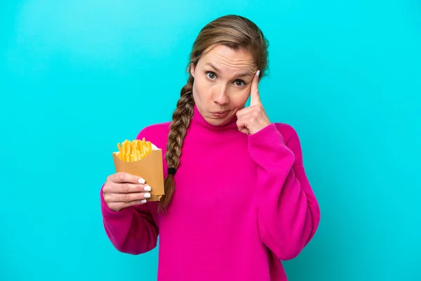 Junge Kaukasische Frau Mit Frittierten Chips Isoliert Auf Blauem Hintergrund — Stockfoto