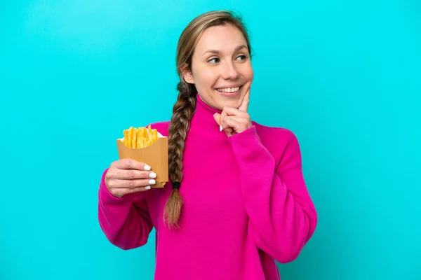 Joven Mujer Caucásica Sosteniendo Patatas Fritas Aisladas Sobre Fondo Azul — Foto de Stock