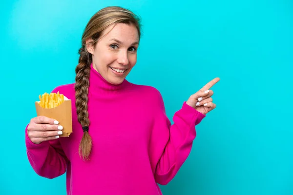 Young Caucasian Woman Holding Fried Chips Isolated Blue Background Pointing — ストック写真