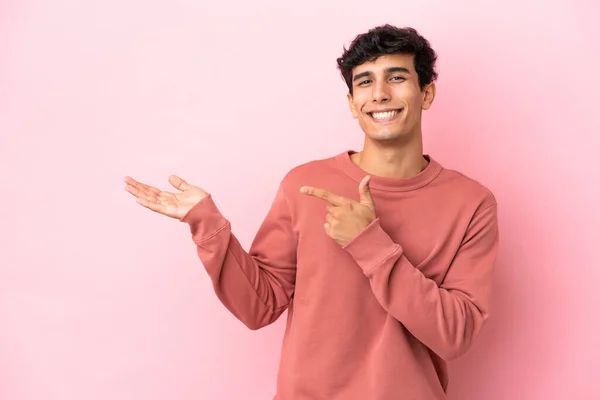 Jonge Argentijnse Man Geïsoleerd Roze Achtergrond Houden Copyspace Imaginaire Palm — Stockfoto