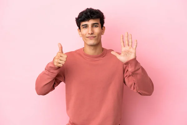 분홍색 배경에 고립된 아르헨티나 남자가 손가락으로 여섯을세고 — 스톡 사진