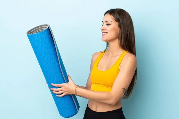 Mujer Deportiva Joven Con Estera Aislada Sobre Fondo Azul Con —  Fotos de Stock