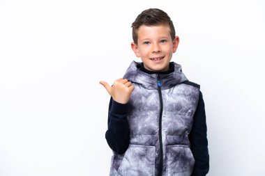 Beyaz arka planda izole edilmiş küçük çocuk bir ürün sunmak için kenarı işaret ediyor.