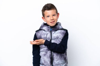 Beyaz arka planda izole edilmiş küçük çocuk gülümseyerek bir fikir sunuyor.