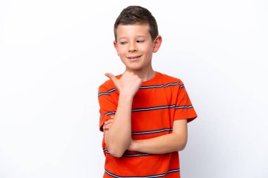 Beyaz arka planda izole edilmiş küçük çocuk bir ürün sunmak için kenarı işaret ediyor.