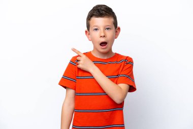 Beyaz arka planda izole edilmiş küçük çocuk şaşırmış ve işaret ediyor.