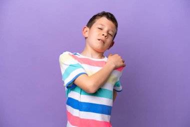 Küçük çocuk mor arka planda izole edilmiş. Omuz ağrısı çekiyor. Çabaladığı için.