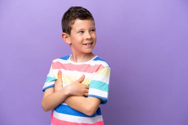 Küçük çocuk mor arka planda izole edilmiş, kolları bağlı ve mutlu.