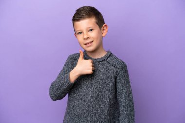 Mor arka planda izole edilmiş küçük bir çocuk baş parmak işareti yapıyor.
