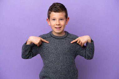 Küçük çocuk mor arka planda izole edilmiş, şaşırmış bir yüz ifadesi var.
