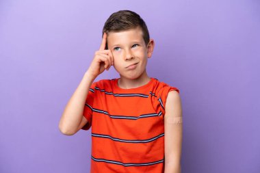 Mor arka planda yara bandı takan küçük çocuğun şüpheleri ve kafa karıştırıcı bir yüz ifadesi var.