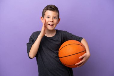 Mor arka planda, ağzı açık bağırarak basketbol oynayan küçük çocuk.