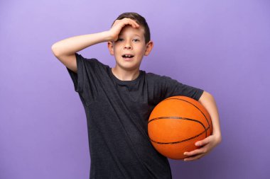 Mor arka planda basketbol oynayan küçük çocuk yan tarafa bakarken sürpriz jest yapıyor.