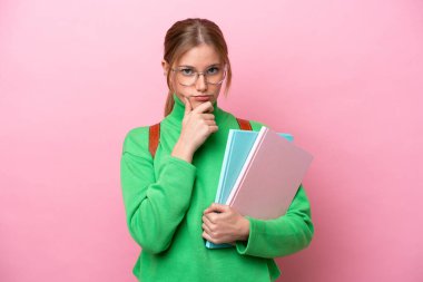 Pembe arka planda izole edilmiş beyaz bir kadın öğrenci.