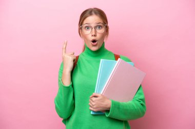 Pembe arka planda izole edilmiş genç beyaz kadın parmak kaldırarak çözümü bulmaya çalışıyordu.