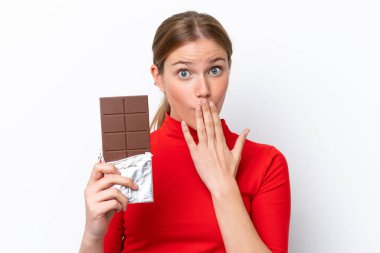 Beyaz arka planda izole edilmiş beyaz bir kadın çikolata tableti alıyor ve şaşırıyor.