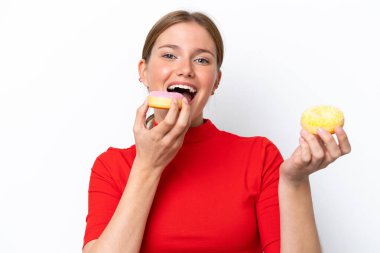 Beyaz arka planda izole edilmiş beyaz bir kadın donut yiyor.